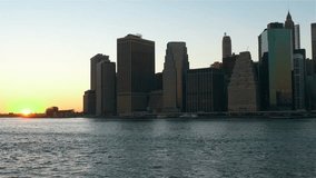 Fast motion footage of Manhattan skyline from Brooklyn side at sunset, New York City. No camera movement.