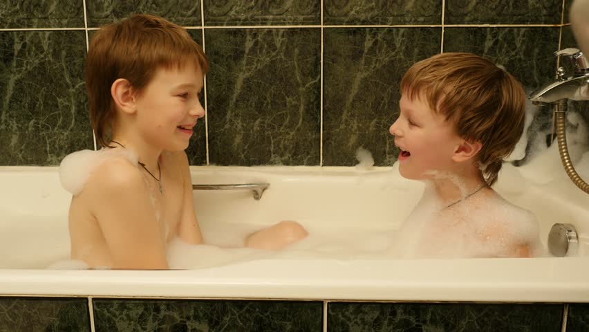 Two little brothers taking a bath with foam, 4k footage.