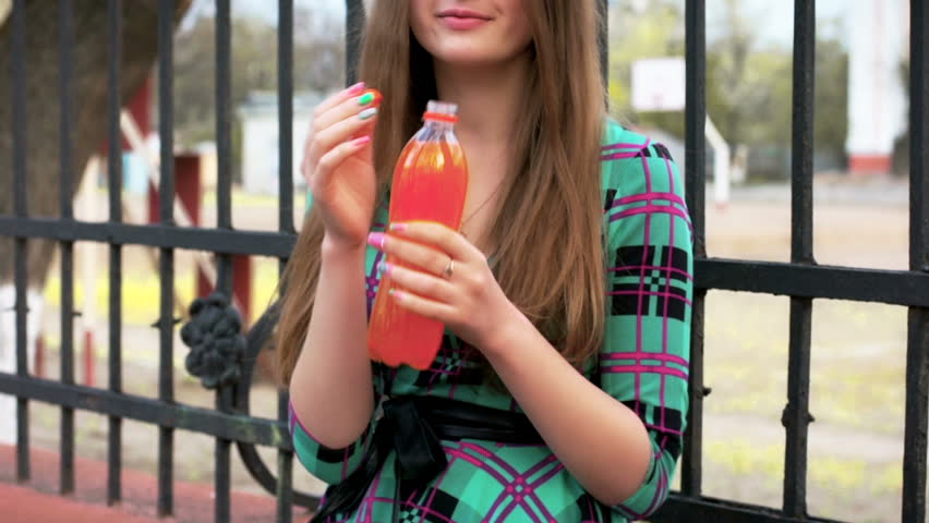 Beautiful woman drinking orange soda