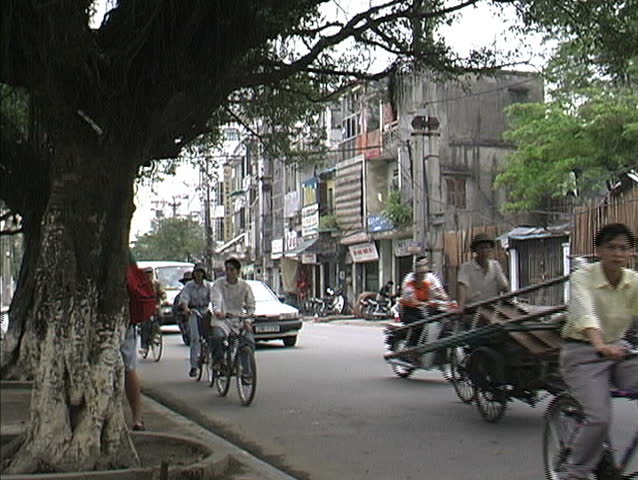 HANOI, VIETNAM - CIRCA APRIL 1998: Unidentifed people ride bicycles on a street in Hanoi.  