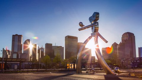 Dallas, Texas/USA - 03/31/2016: Dallas Sunset Time Lapse: The Travelling Man is a steel sculpture located at the Deep Ellum Station in Dallas. Sculptures by Brad Oldham and Brandon Oldenburg.
