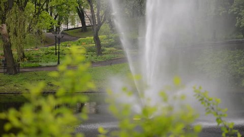 Fountain in a City Park. In an early morning, through a green bushes, in a green park, in the greenest district of the 15th greenest capital of Europe - Riga.