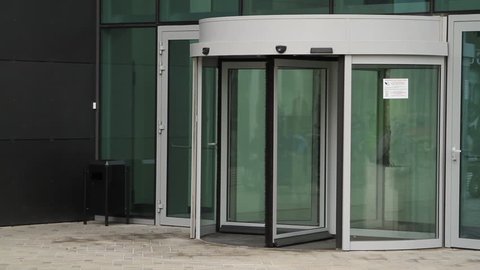 Business woman entering modern building with offices. Businesswoman entering revolving door.