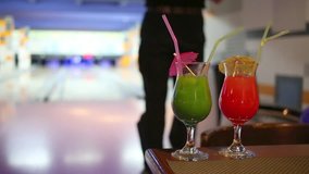 Two bright cocktail on a table on the background of man playing bowling - Powered by Shutterstock - Get 15% off with code: PIKWIZARD15