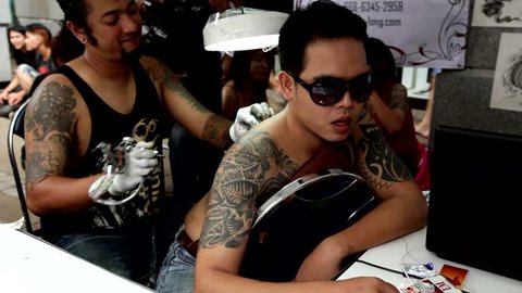 BANGKOK , THAILAND - OCTOBER 23, 2014 : 
A man is getting a  tattoo on his back during the MBK tattoo contest 2014 in Bangkok Thailand.
