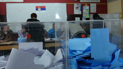Krusevac,Serbia,24.04.2016. Parliamentary elections. Man vote on elections, people put ballot in boxes, voting close up, tilt down, commission checking identity of voters. Civic duty, insert, indoor.