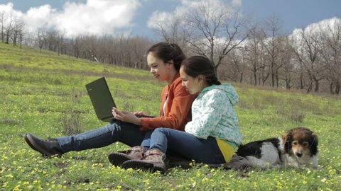Girls in nature with laptop