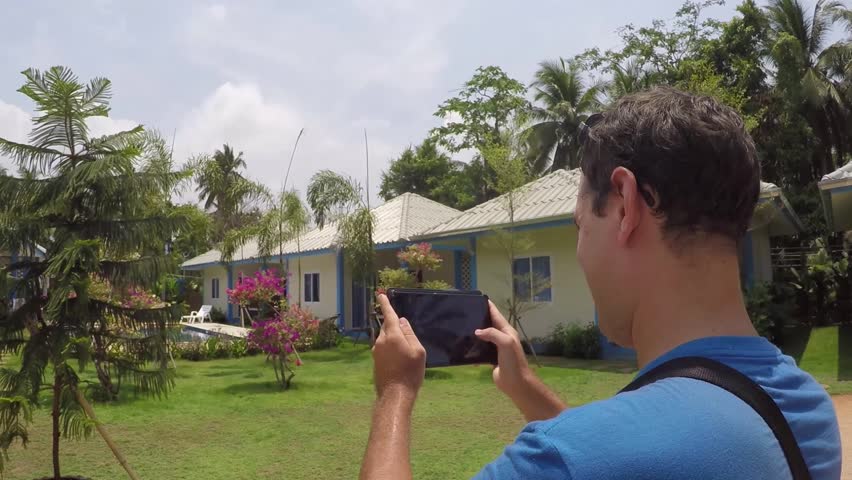 A young man is taking pictures of a resort in Thailand, Koh Samui