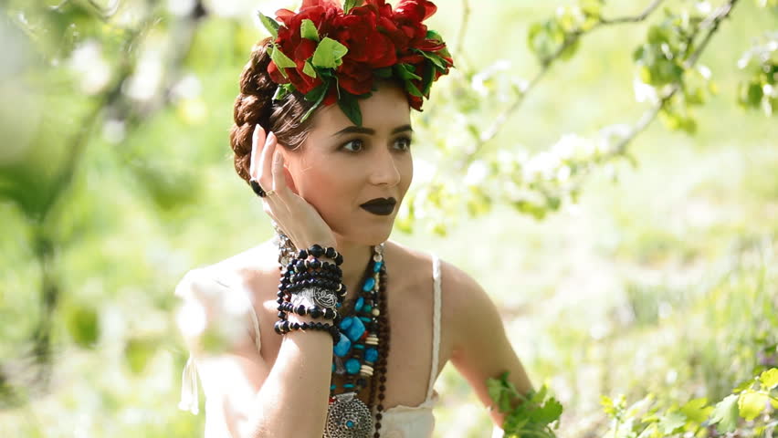 Young woman in national  mexican dress pose to photographer in green floiage.  Image of Frida Kahlo.