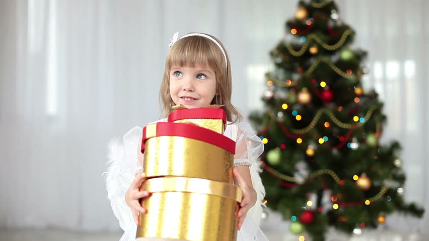 Child with gifts near the Christmas tree 