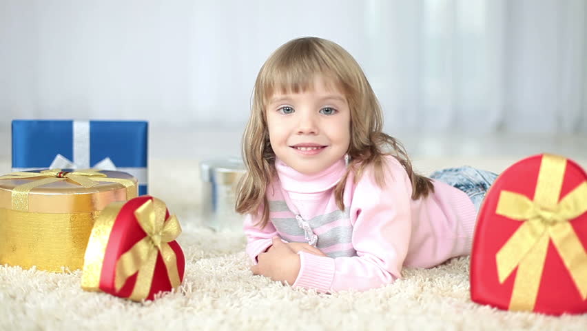 Girl with gifts lying on the carpet 