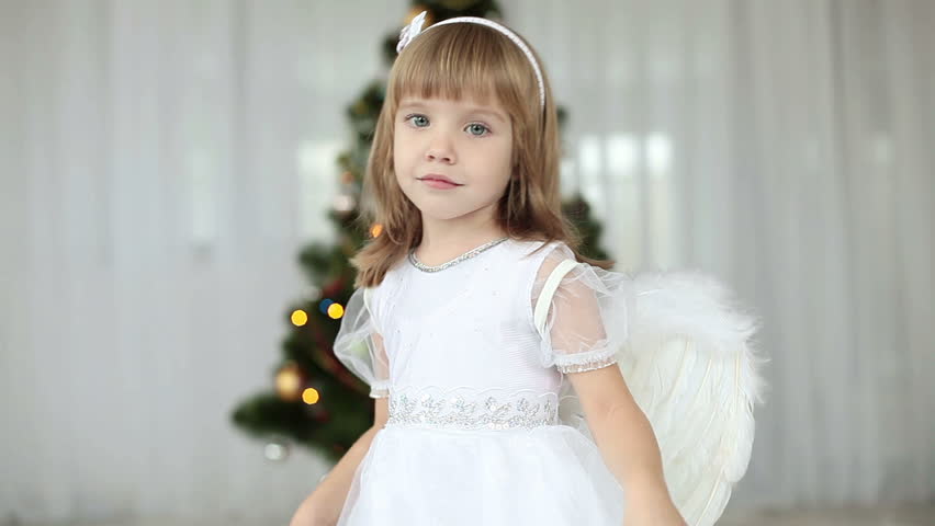 Happy angel swirls around Christmas tree 