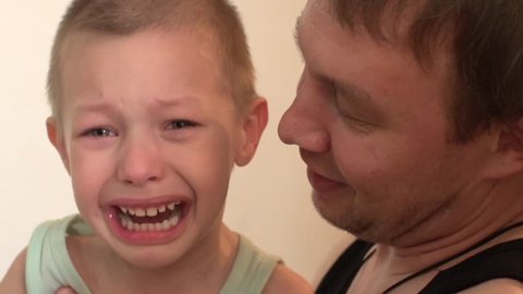 child crying, angry, and beats his father,father of the child calms