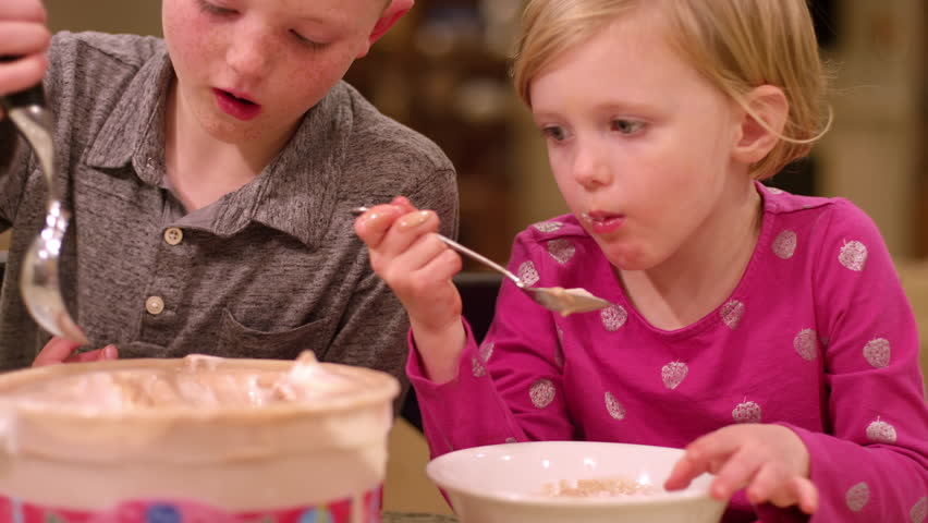 Siblings scooping ice cream at home