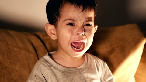 Expressive young kid crying hardly and sobbing . close up of a kid with tears