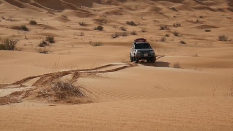 SAHARA DESERT, TUNISIA - CIRCA OCTOBER 2015:  an off road car on a dune in the Sahara desert, Tunisia.