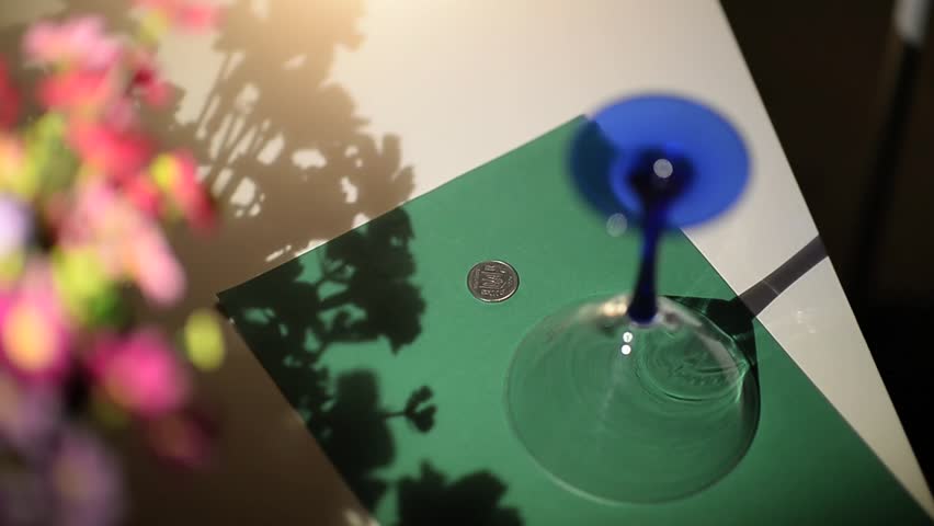 A person covers a glass coin and a handkerchief