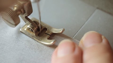 sewing machine and item of grey clothing close up