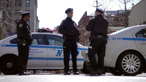 NEW YORK - MAY 21, 2016: three officers talking - police cars in 4K video in NYC. NYPD is the department responsible for law enforcement in the 5 boroughs of the city.