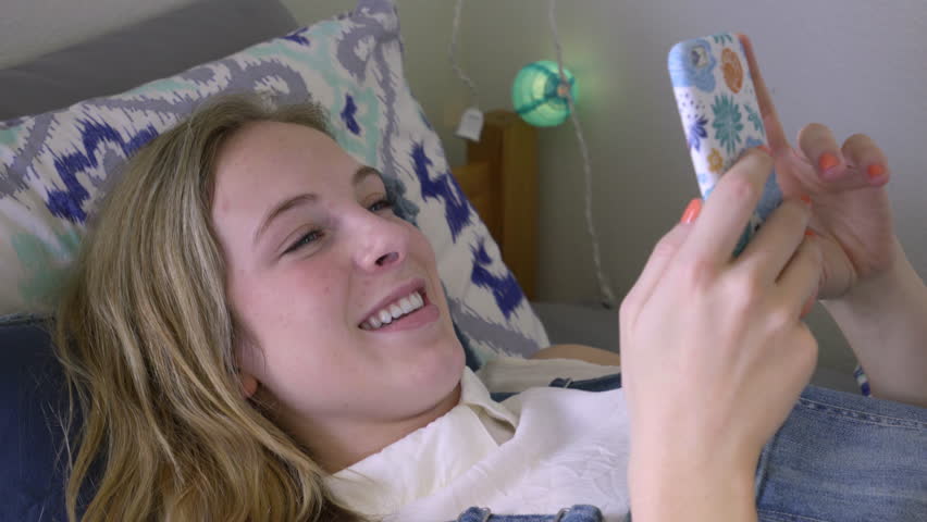 Closeup Of Girl Laughing At Her Smartphone, She Scrolls Through Photos
