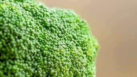 Macro of broccoli veggie being washed with squirts of water shot in slow motion