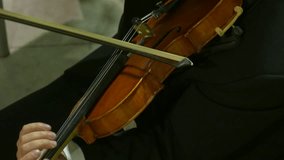 Ungraded: Violinist playing / Violin Player / Orchestra Musician. Male violinist plays violin at a classical music concert. Violin close-up. Source: Lumix DMC, ungraded H.264 from camera. (av24763u)