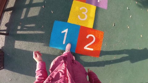 Girl jumps hopscotch on children playground, First Person View