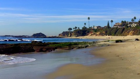 Shot of a rocky beach and coastline at Aliso Beach County Park in Laguna Beach, California. This clip features a beautiful scenic shot of the waves of the Pacific ocean lapping at the rocky shore. 