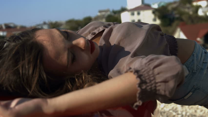 Sexy model lying on the hood of the car and posing