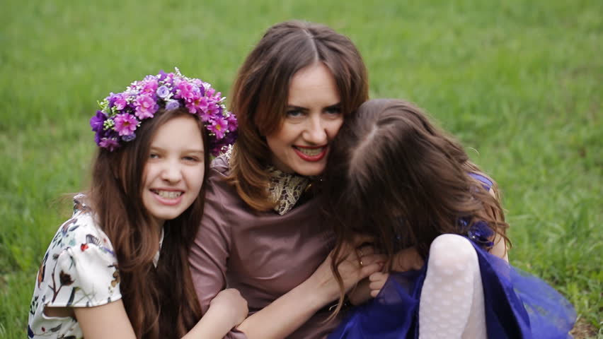 Young mother and two daughters playing in grass