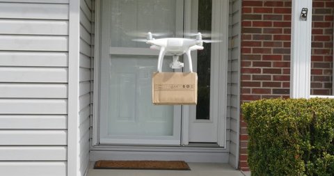 A small drone delivers a package to a residence.  	