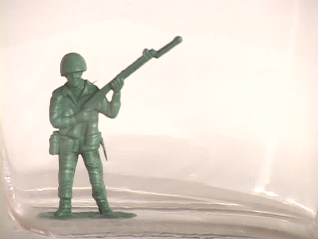 Oil  fills up a container drowning a plastic soldier, symbolizing the nation and military drowning in oil.