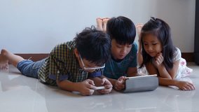 Young asian boys playing online games on tablet computer and smart phone