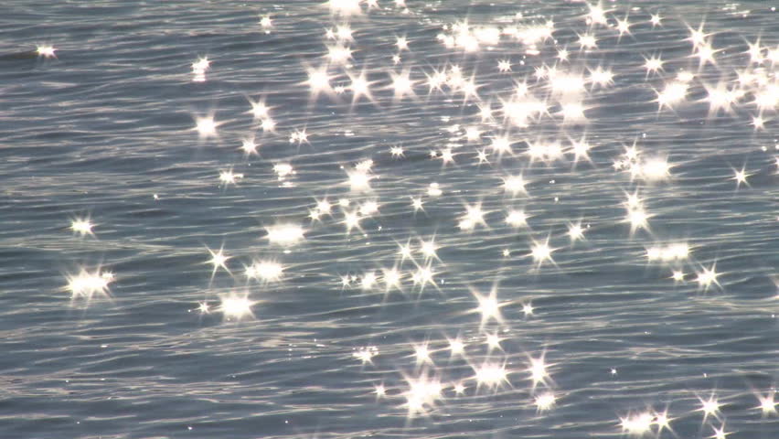 Scintillating sun reflections create diamond stars on the waves near shore.