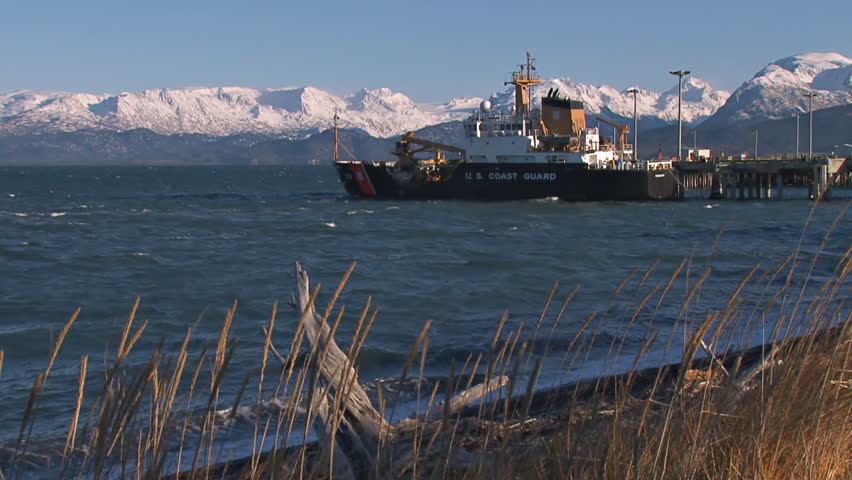 United States Coast Guard cutter docked in Kachemak Bay off the Homer Spit on a vibrant, windy autumn day.