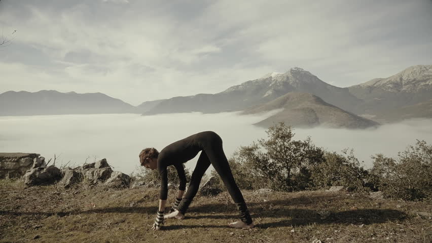 Woman exercizing yoga in Greek nature,mountain,village,winter time,morning.A woman doing yoga exercizes outside in nature in the beautiful Greek mountain village of Goura
