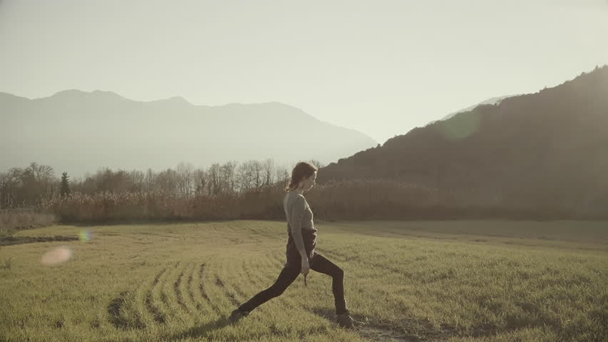 Woman exercizing yoga in Greek nature,grass field,tall trees.A woman doing yoga exercizes outside in nature in the beautiful Greek mountain village of Goura