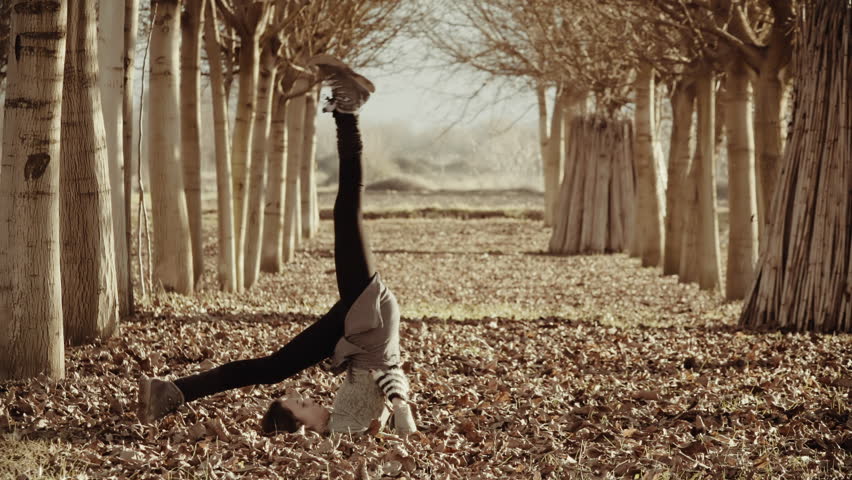 Woman exercizing yoga in Greek nature,grass field,tall trees.A woman doing yoga exercizes outside in nature in the beautiful Greek mountain village of Goura