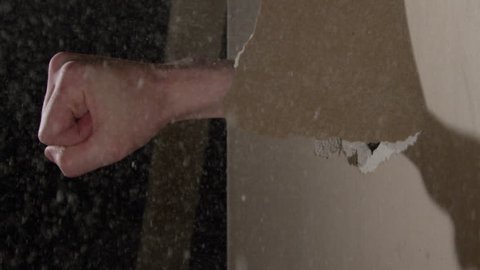 Smashing through Drywall in slow motion - fist coming through the wall