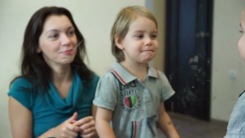 Little girl with mother doing make up. A woman of European appearance 25-30 years old and her daughter 3-4 years old face a mirror.