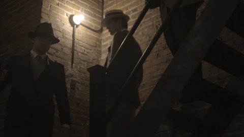 NEW YORK CITY - SEPTEMBER 2013.  Re-enactment, recreation of 1920s, 1930s Gangster/Mobster in Dark Hallway, walk down staircase together.  Mobster, mob boss during prohibition days. Boardwalk Empire.