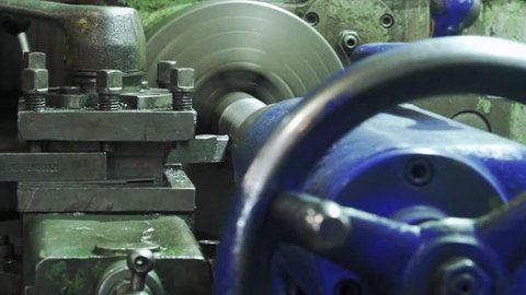 Turning lathe in action.Facing operation of a metal blank on turning machine with cutting tool.Old turning lathe machine in turning workshop.Operator machining high precision mold part by cnc lathe