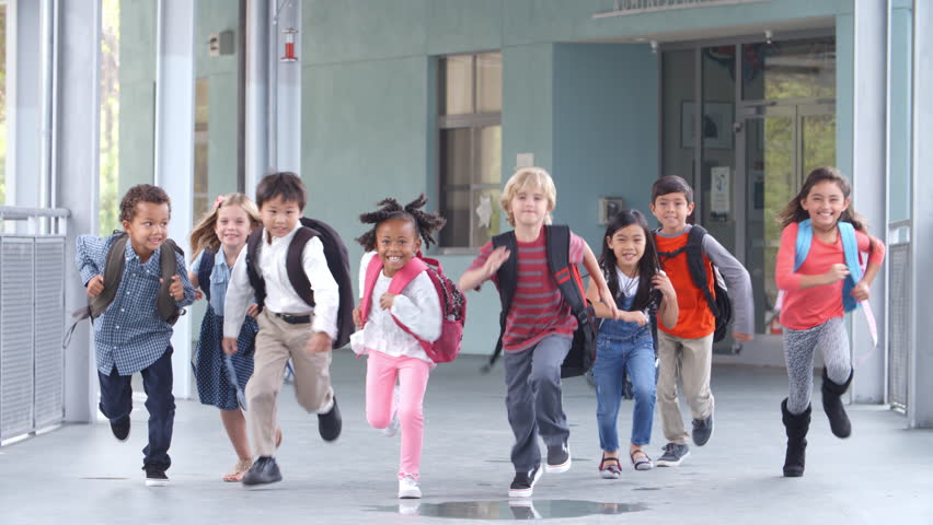 Group of elementary school kids running in a school corridor