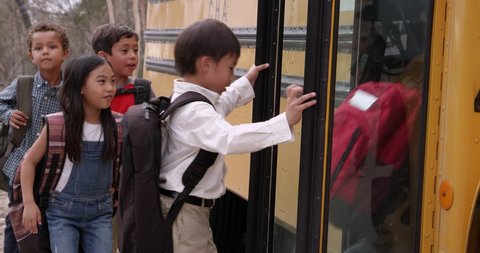 Young elementary school kids boarding a school bus