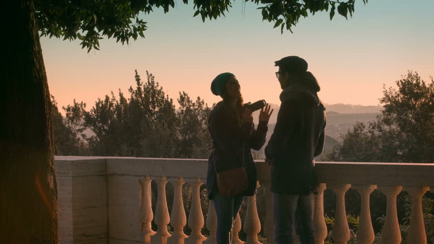 couple of young lovers cheerful playing on a terrace of a public park