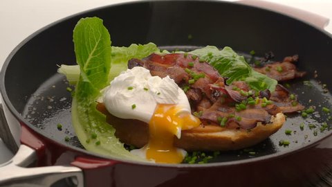 Sandwich with poached egg, salad and bacon