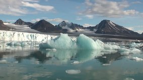Sea mountains and large icebergs reflecting in the water.  Fantastic wonderful amazing video grennlandii nature iceland. Lovely shooting the life of nature, seaside and mountains.