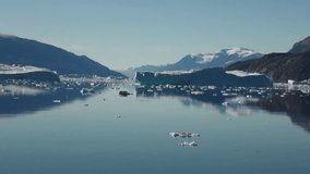 Sea mountains and large icebergs reflecting in the water.  Fantastic wonderful amazing video grennlandii nature iceland. Lovely shooting the life of nature, seaside and mountains.