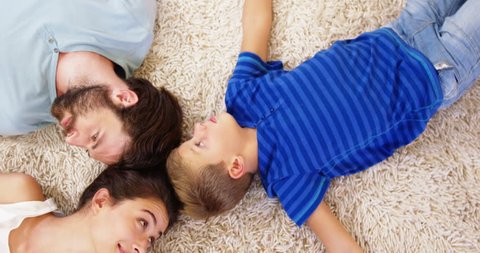 Happy family lying on carpet and pointing the camera at home Social distancing and self isolation in quarantine lockdown for Coronavirus Covid19