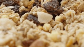 Crunchy muesli mixed of corn flakes and dried fruit slow tilt 4K 2160p 30fps UltraHD video - Food background of cereals pile in bowl 4K 3840X2160 tilting UHD footage